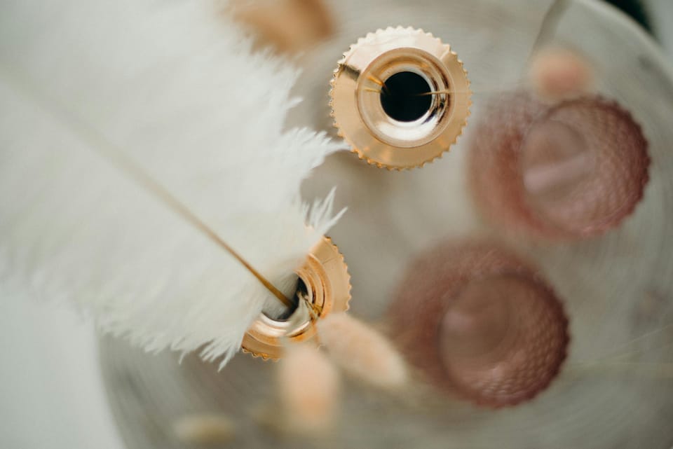 A close-up of a white quill resting in a golden inkwell, softly blurred and glowing with warm tones—symbolizing forgotten authorship and the quiet dignity of unclaimed influence.
